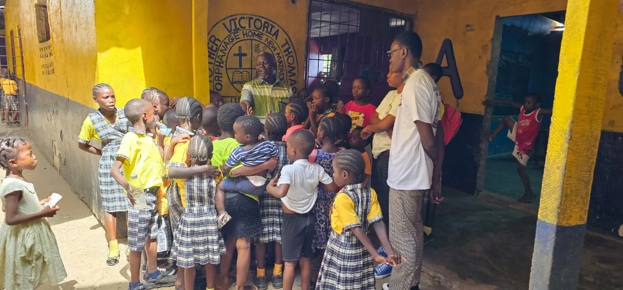 Children in yellow and plaid school uniforms lined up outside their classrooms