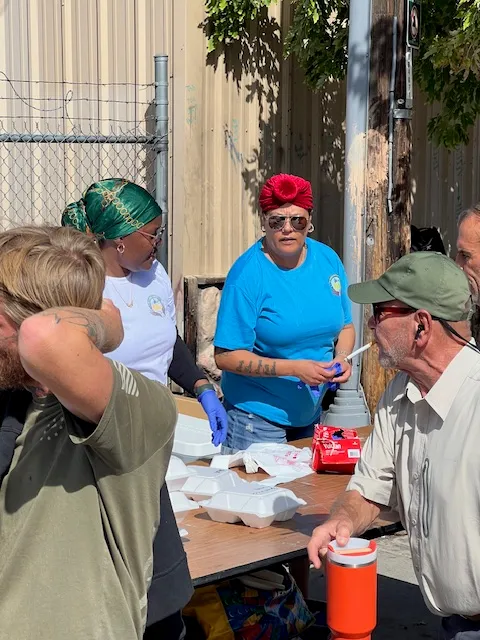 Volunteers talking with neighbors at the meal table