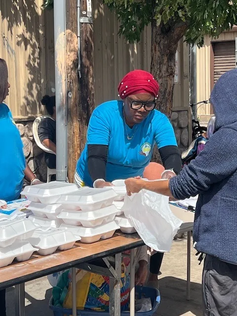 A volunteer handing out packed meals