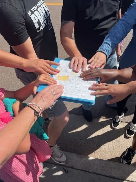 Volunteers joining hands before an outreach