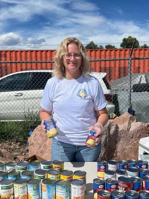 A Kyne Hands Foundation volunteer holding canned food at an outreach