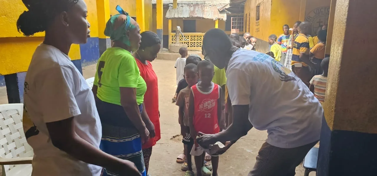 Kyne Hands Foundation volunteers handing gifts to children in the orphanage courtyard